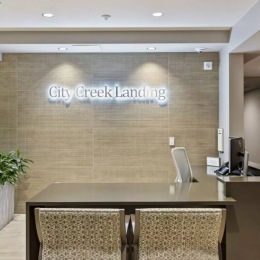 a reception desk with a sign seating and computer