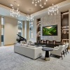 large lounge with seating and tv and windows